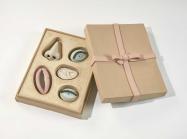 Genesis Belanger ceramic sculpture of a box of chocolate with facial features instead of chocolates
