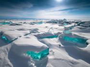 a snowy landscape with bit of brilliant blue ice