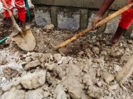 people digging in rubble