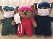 three crocheted teddy bears in scrubs and face masks