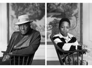 Black and white photo of seated Fred Stewart II and Tyler Collins. Both look at camera.