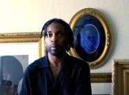 image of Fagan in front of pictures looking at camera