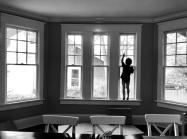 the silhouette of a child standing in a bay window
