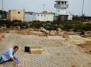 An Israel Antiquities Authority conservationist works on the 'Jesus' mosaic excavated at a prison in Megiddo in northern Israel, part of a structure from the third or fourth century that may be one of the earliest Christian churches. (Yoli Schwartz/IAA)