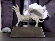 Hand touching bronze dog statue