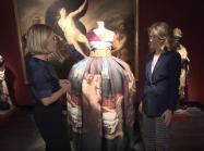 Examining dress with painting in background