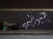 banksy mural of reindeer pulling a public bench