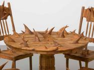 a circular wooden table and chairs, all covered in large thorny protrusions