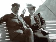 Photograph of Wilhelm and Henny Hansen smoking in front of water 