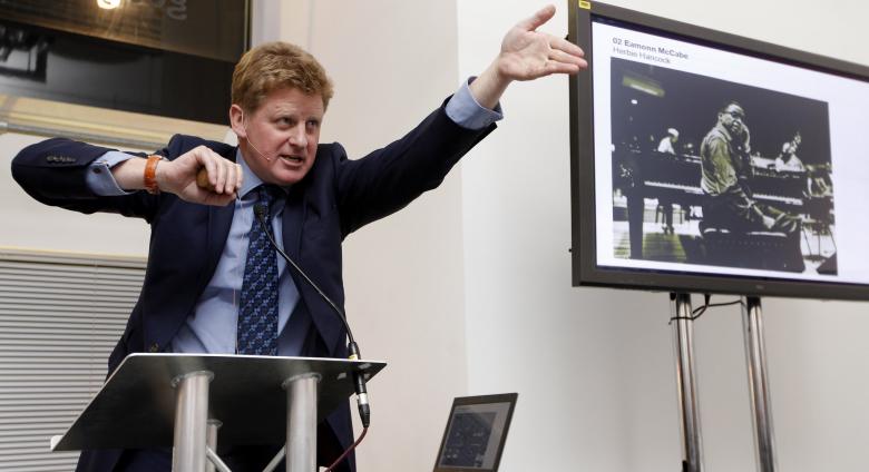 Sotheby's auctioneer Adrian Biddell gesticulates as he takes bids