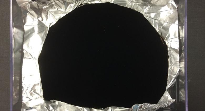 Wrinkled aluminium foil with a portion—equally wrinkled—coated in Vantablack. Courtesy Wikimedia Commons. Photo Anna Frodesiak and Surrey NanoSystems.