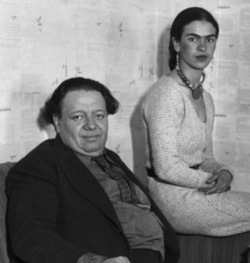 Frida sits behind and above Diego