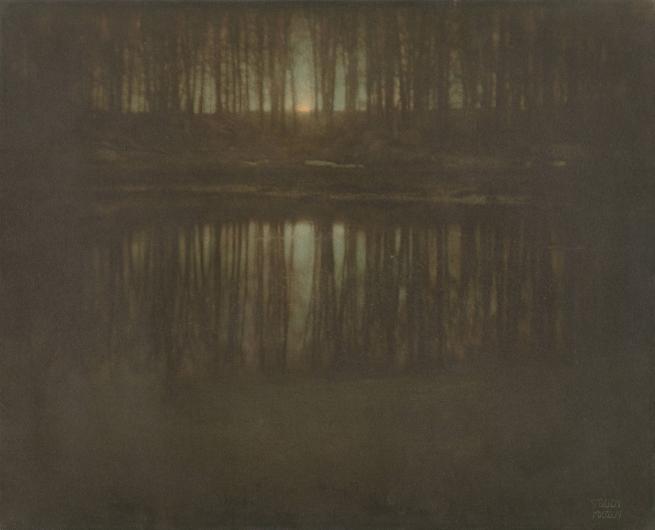 Edward Steichen photograph of a pond at night with the moon rising through trees behind it