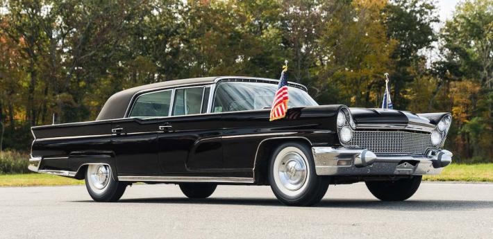 Black Lincoln car with american flags on the front