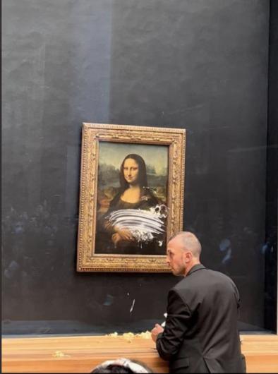 Leonardo’s Mona Lisa under cake-smeared protective glass. Image from Twitter, posted by user @xqTTs.
