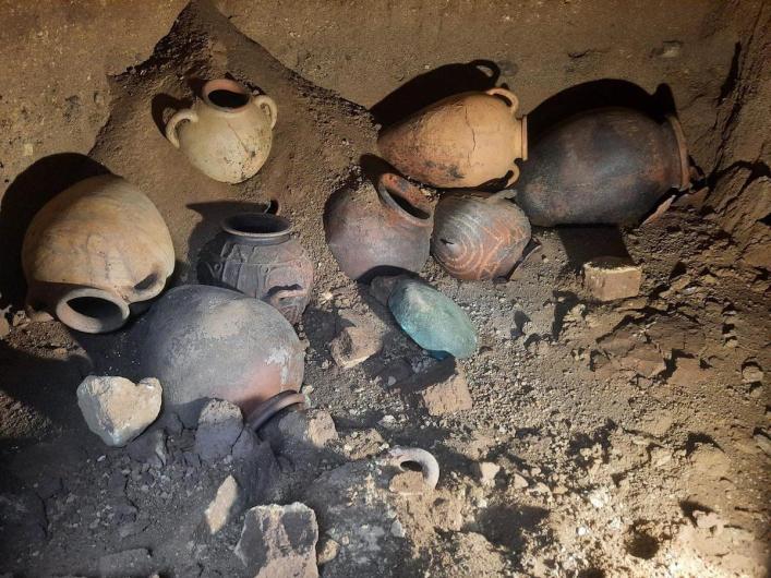 Pottery and Metal vessels located inside the previously untouched 2,600 year-old Etruscan tomb at the archaeological site of Vulci in central Italy. Credit: Municipality of Montalto di Castro.